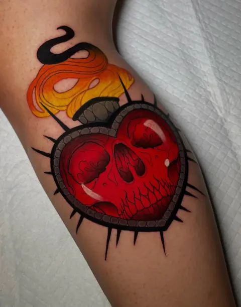 Tatuaje a color de un corazón en llamas con calavera